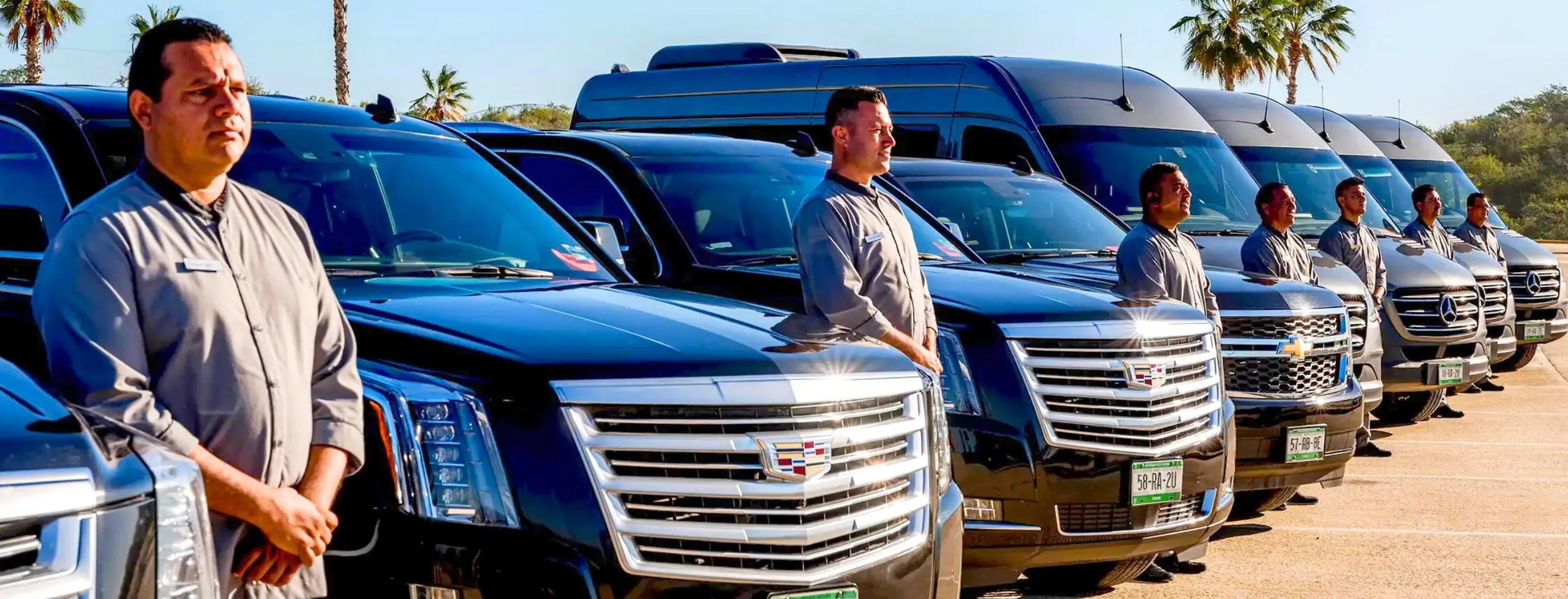 Transcabo drivers standing beside a line of SUVs and passenger vehicles